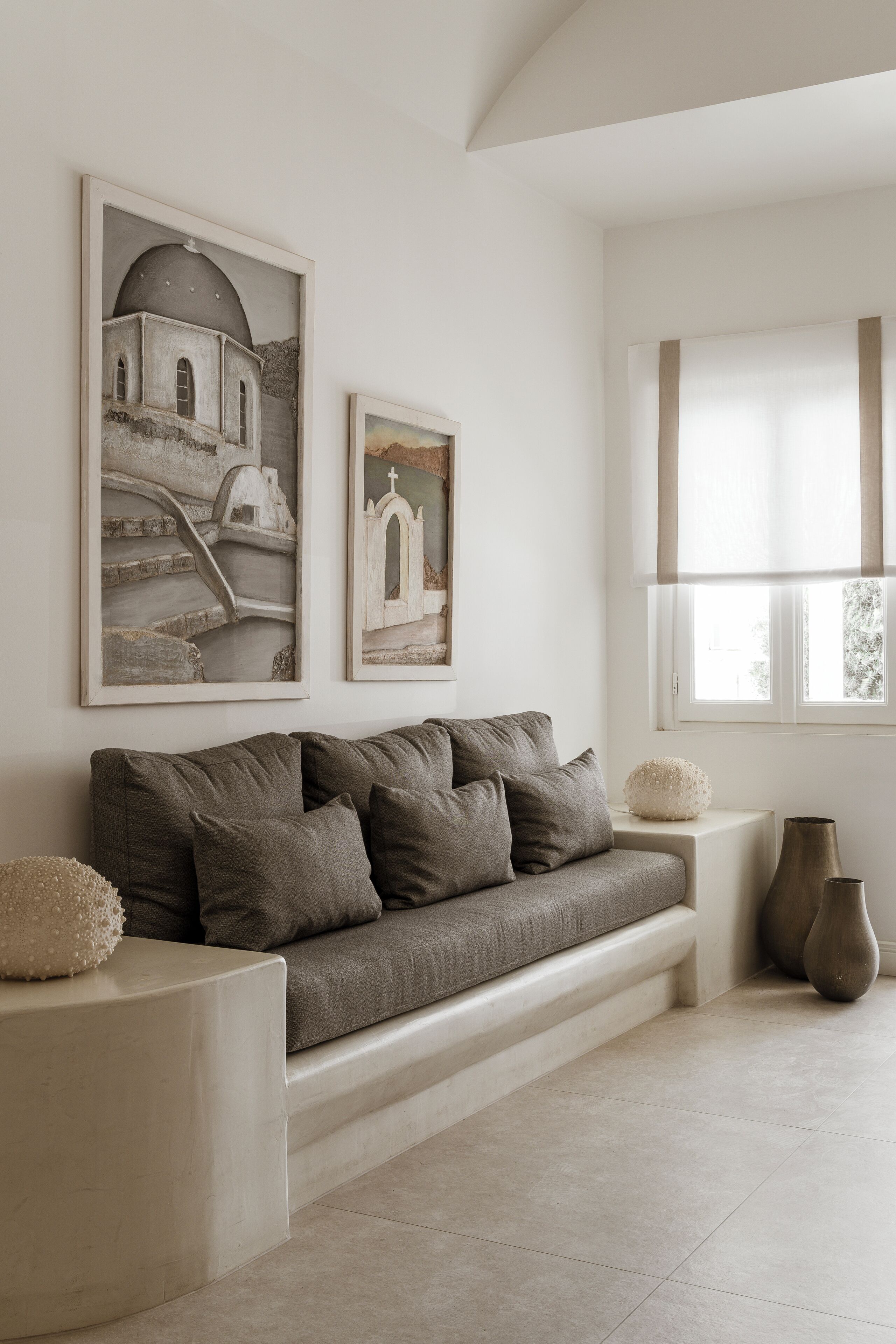 A modern living room with a sofa, two side tables, and artwork on the wall.
