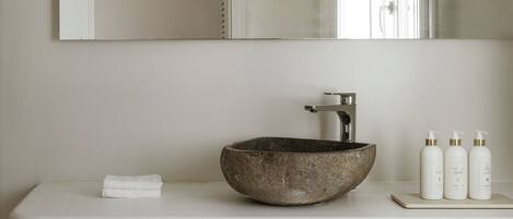 Un bany amb un mirall gran, un lavabo i una barra de tovalloles.