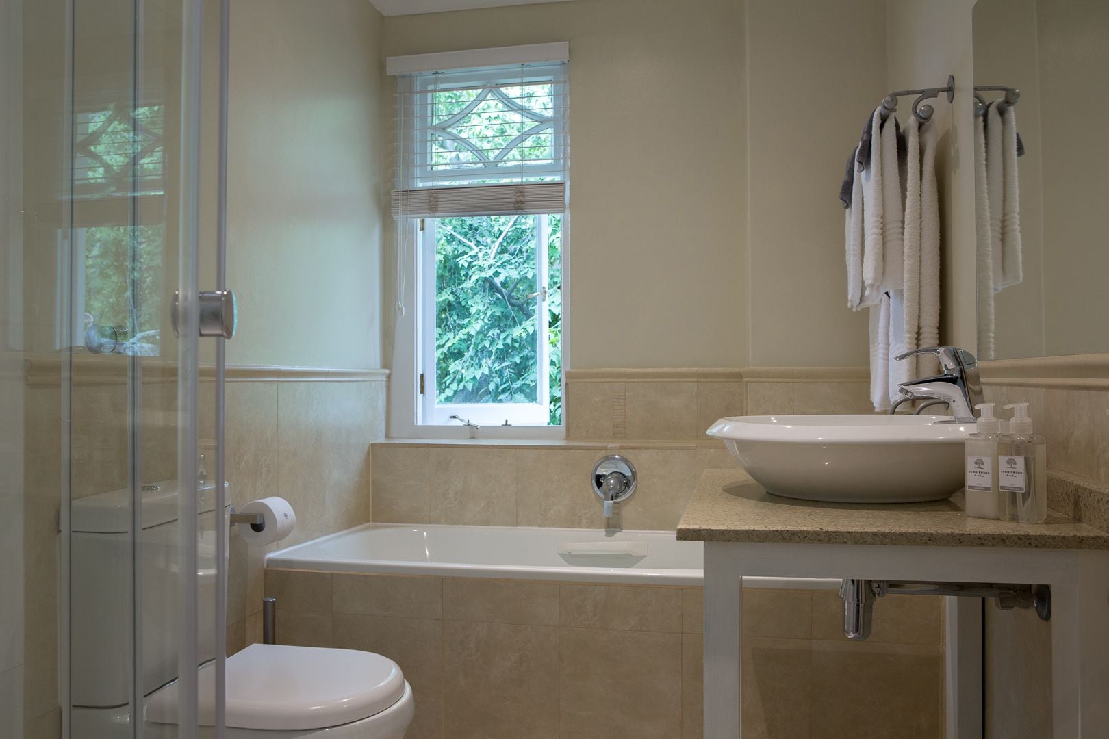 A bathroom with a bathtub, a sink, and a window.