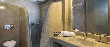 Une salle de bain moderne avec une grande baignoire, des toilettes, un lavabo avec un miroir et des articles de toilette.