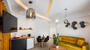 A modern kitchen with a dining area, a sofa, and decorative wall art.