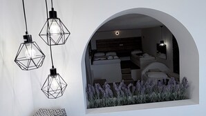 Um interior moderno com um pendente geométrico, uma parede branca e um jardim vertical com plantas de lavanda.