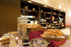 Buffet variado com diversas opções de comida e um espaço para café.