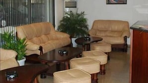 Ein modernes Wohnzimmer mit Ledersofas, einem Couchtisch und Poufs.