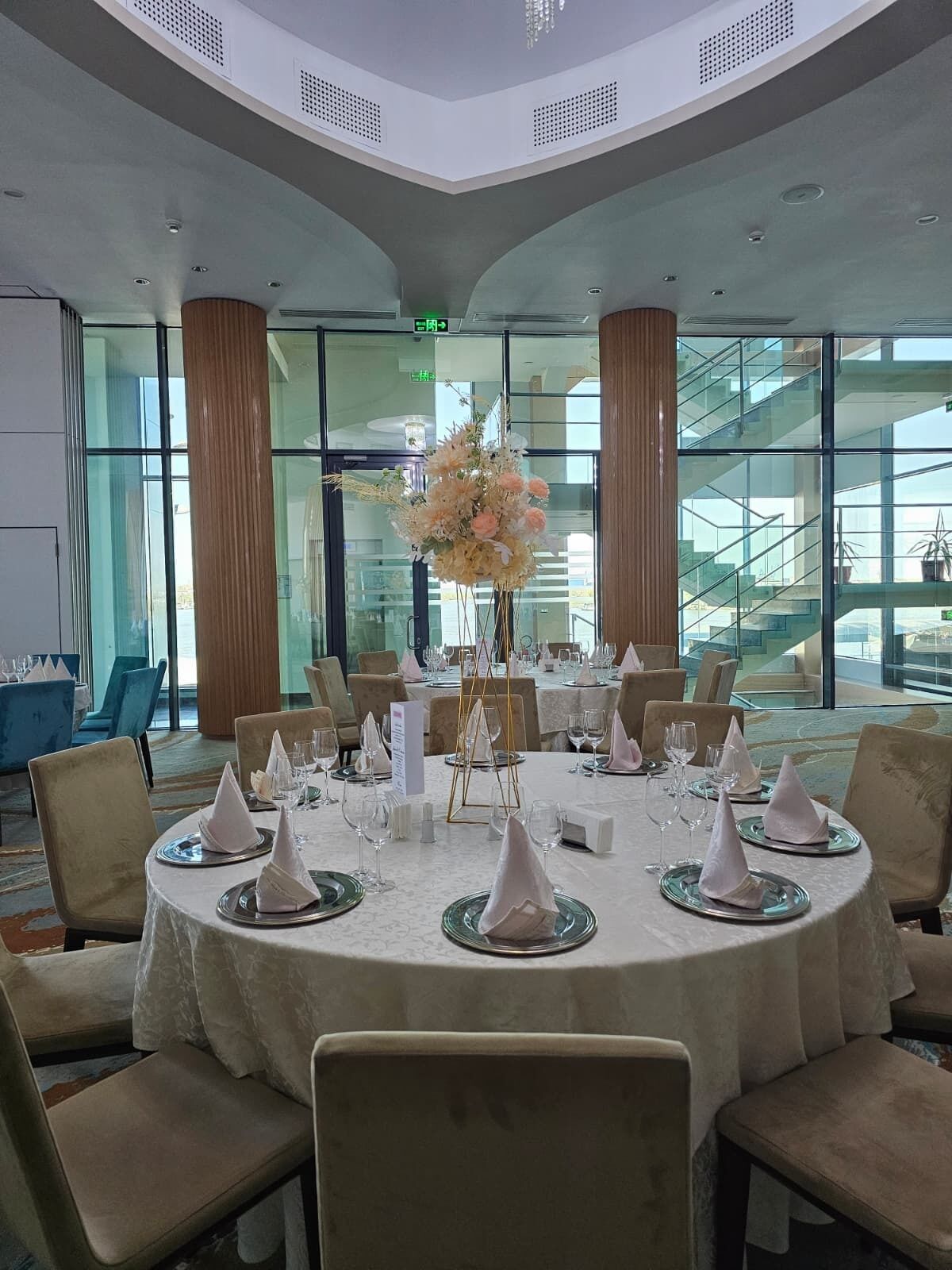 Comedor con mesas redondas, sillas y un ventanal con vistas.