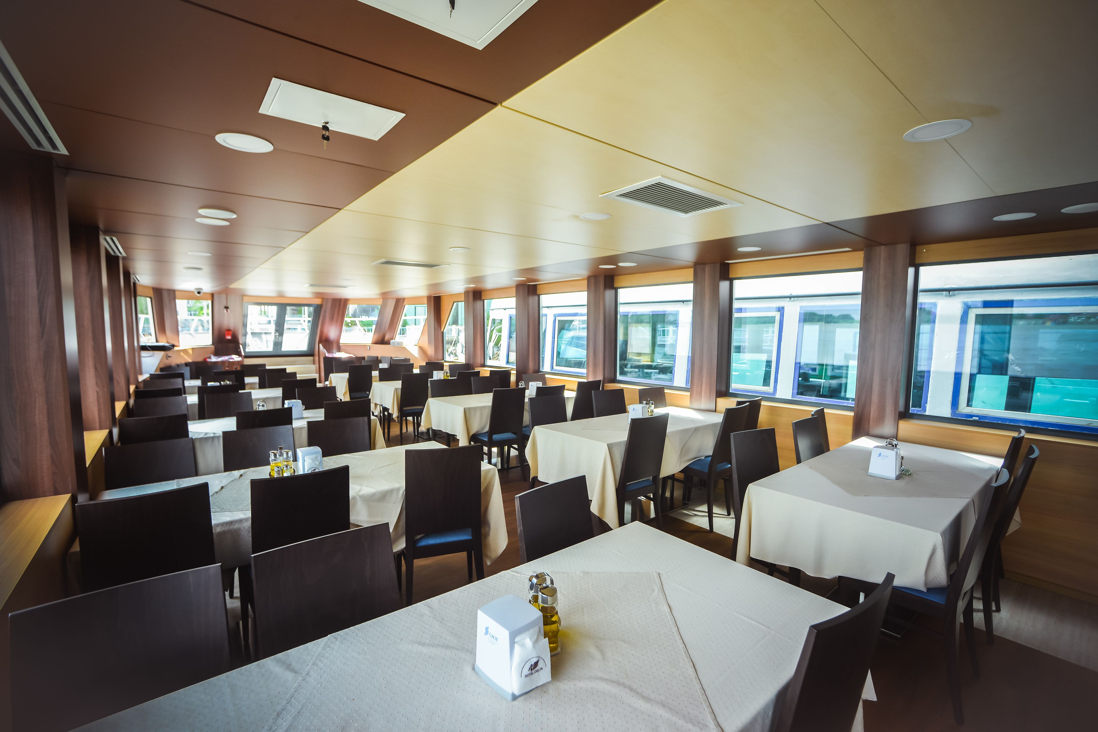 A large dining area with multiple tables and chairs, arranged in rows.