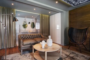 A modern living room with a leather sofa, round coffee table, and a wicker chair. - Majeka House Boutique Hotel (Stellenbosch)