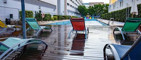 A poolside area with lounge chairs and a swimming pool.