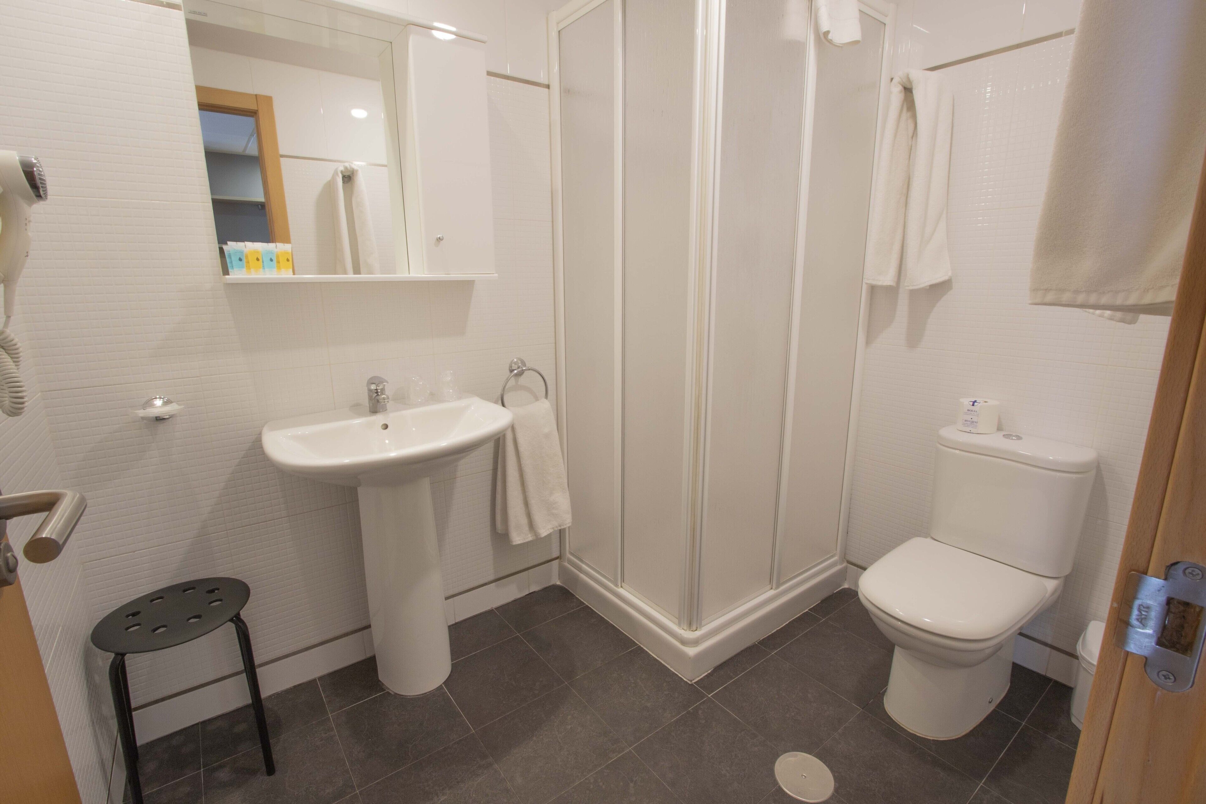 Un baño con lavamanos, inodoro y ducha.