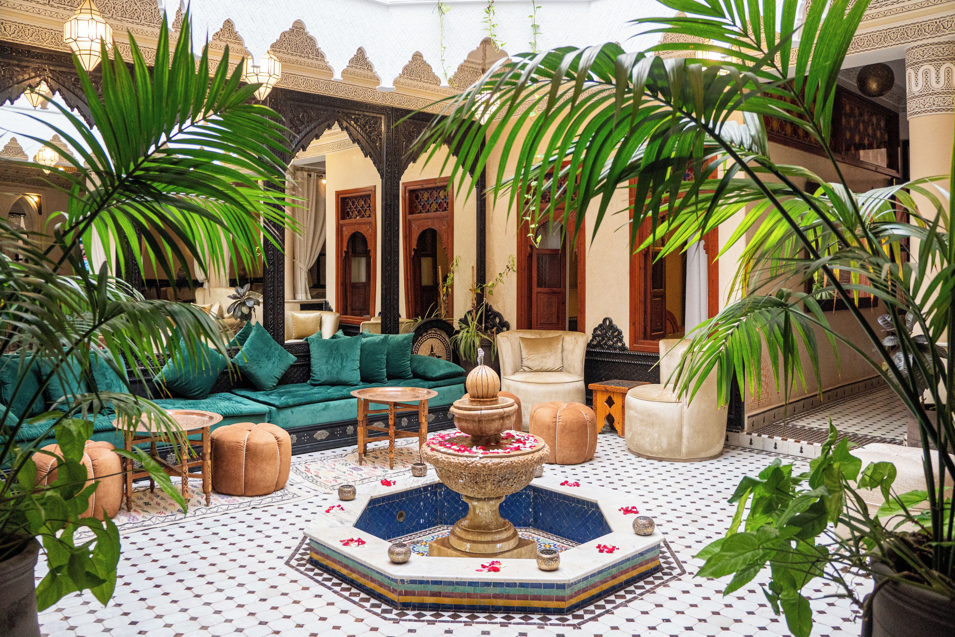 Un interior tradicional con una fuente, asientos y plantas decorativas.