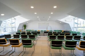 A conference room with rows of chairs, a whiteboard, and large windows. - City Hotel Bucharest (Bucharest)