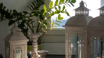 Una habitación con una planta en maceta, un jarrón blanco y faroles decorativos.