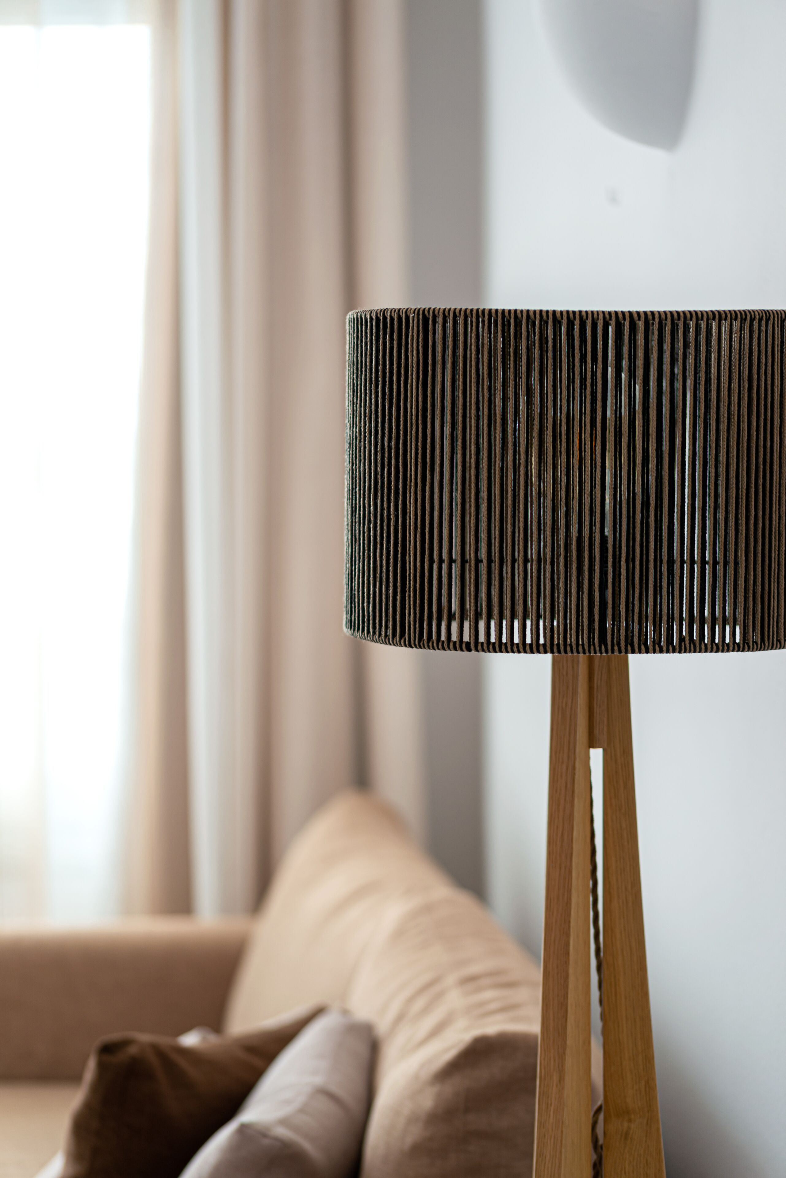 Une lampe avec un abat-jour à motifs en relief, montée sur un pied en bois.