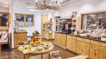 A modern kitchen with wooden cabinets, a central island with fruit bowls, and a coffee station.