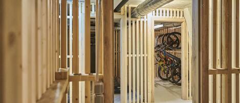 Interior de madera con un perchero para bicicletas y una puerta que da a otra habitación.
