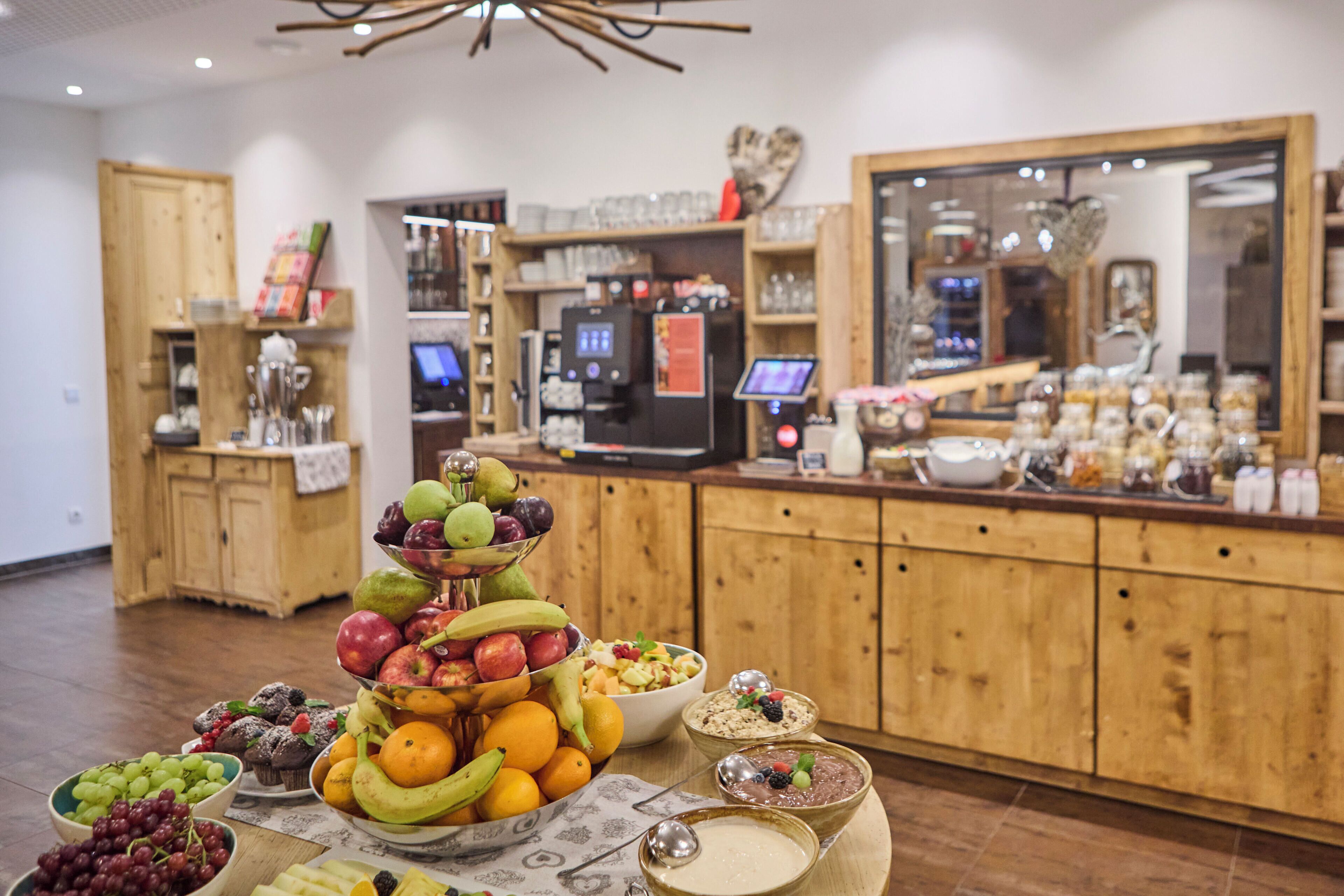 Una mesa de buffet con diversas frutas, postres y bebidas.
