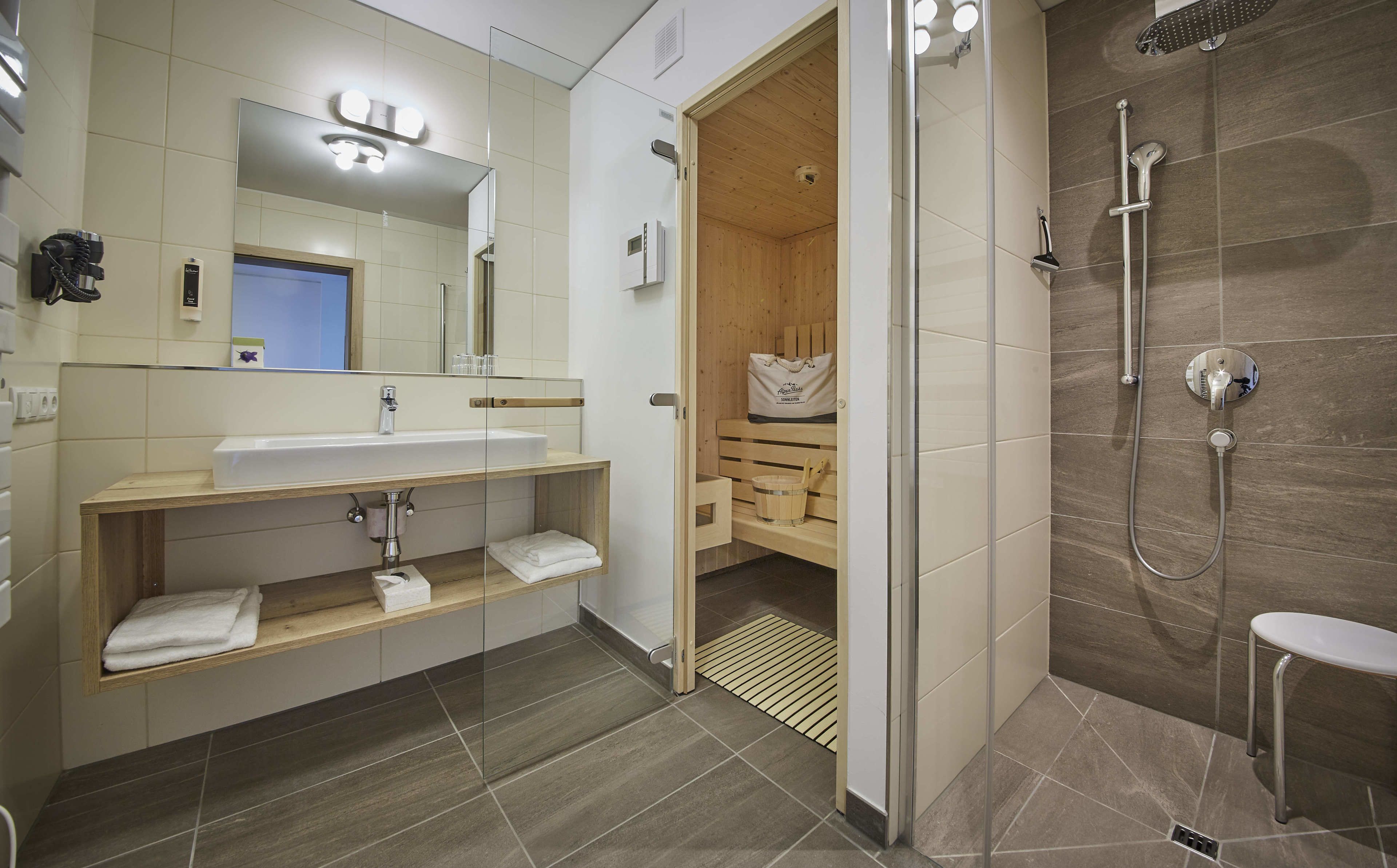 Une salle de bain moderne avec un lavabo, un miroir et une douche.
