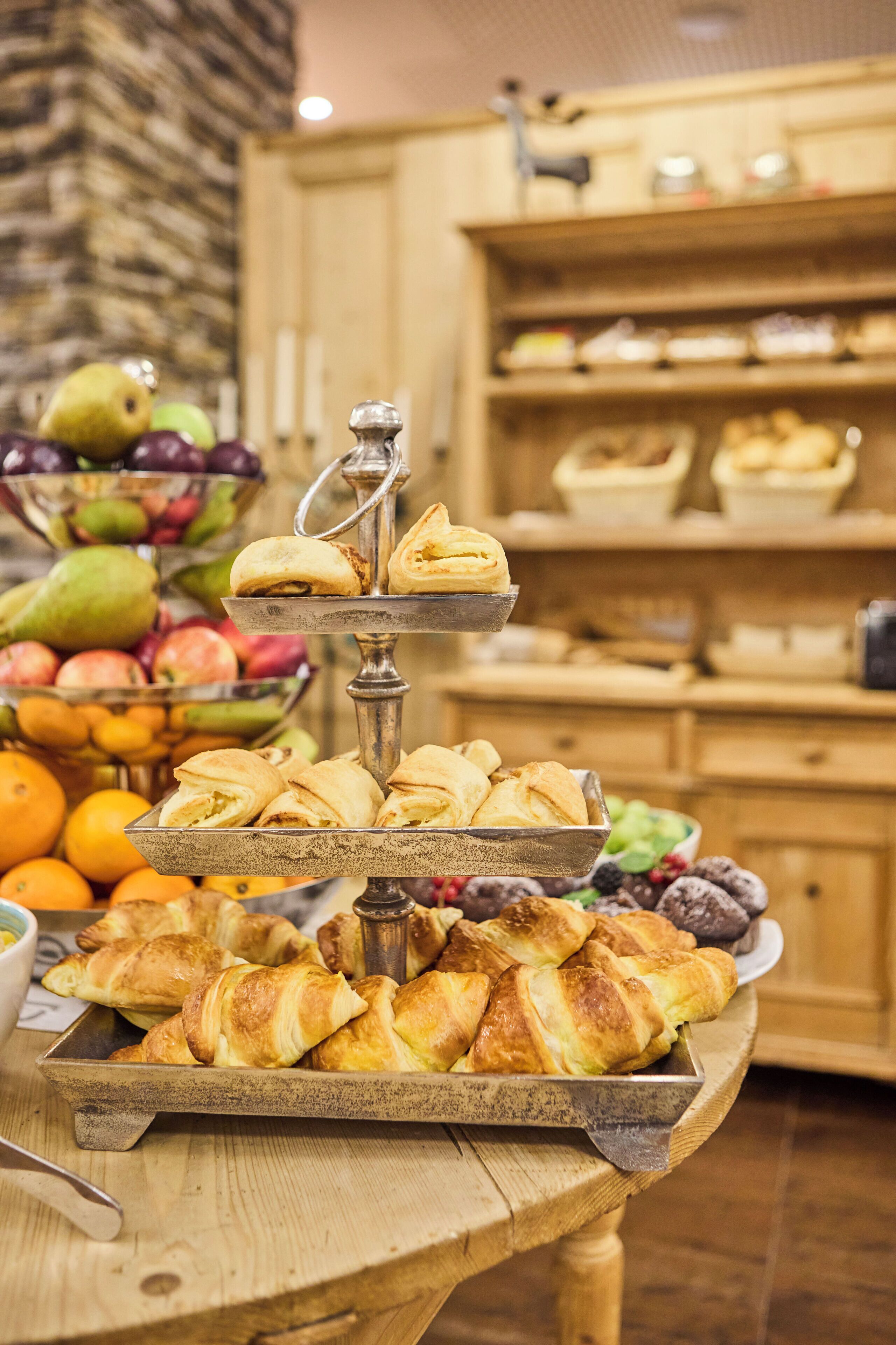 A buffet table with various pastries and fruits.