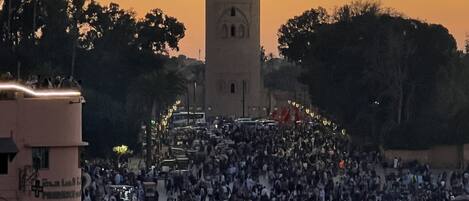 Uma praça movimentada com uma torre imponente ao fundo.