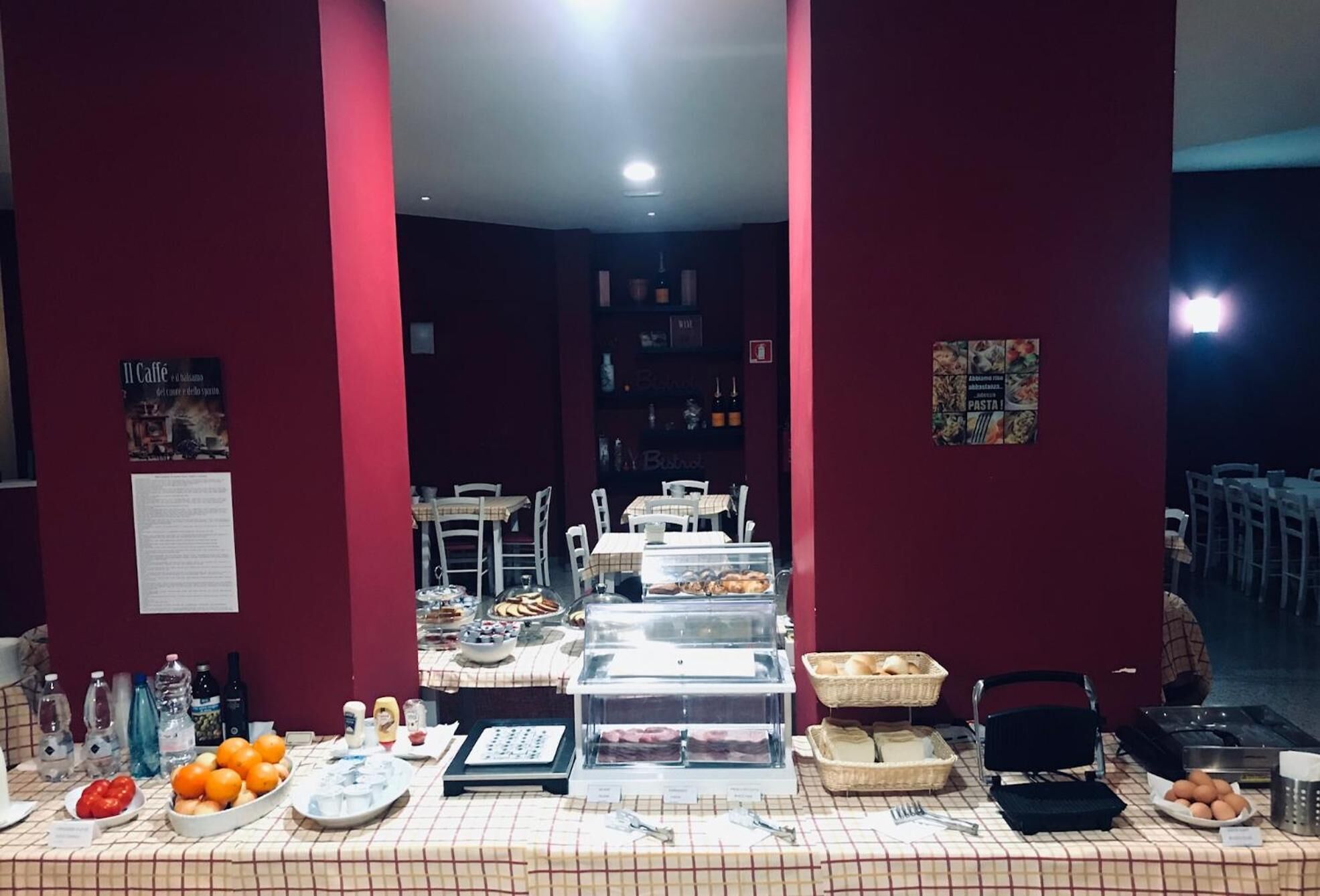 Buffet montado com diversos alimentos e uma área de estar ao fundo.