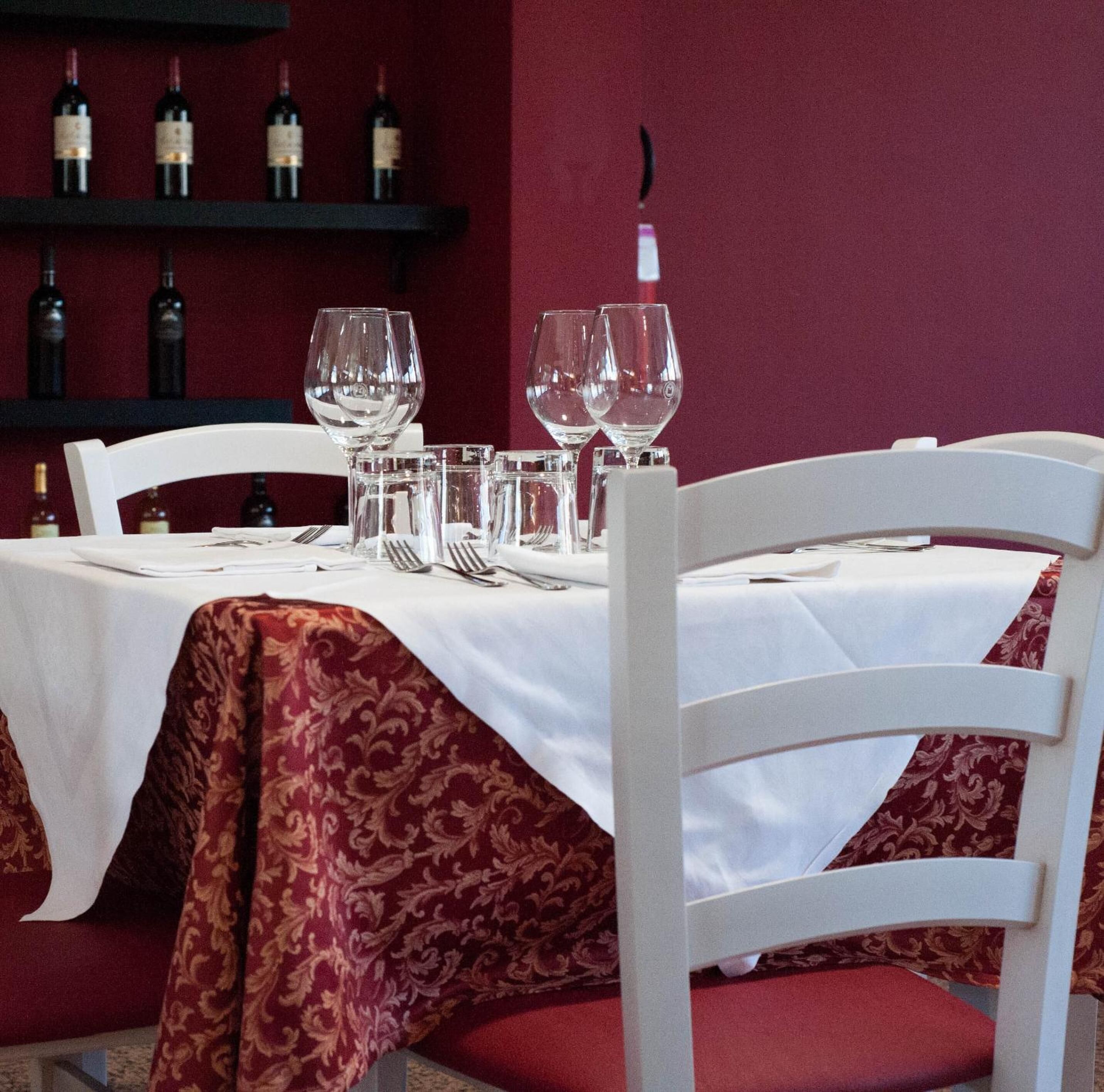 A table set for dining with wine bottles in the background.