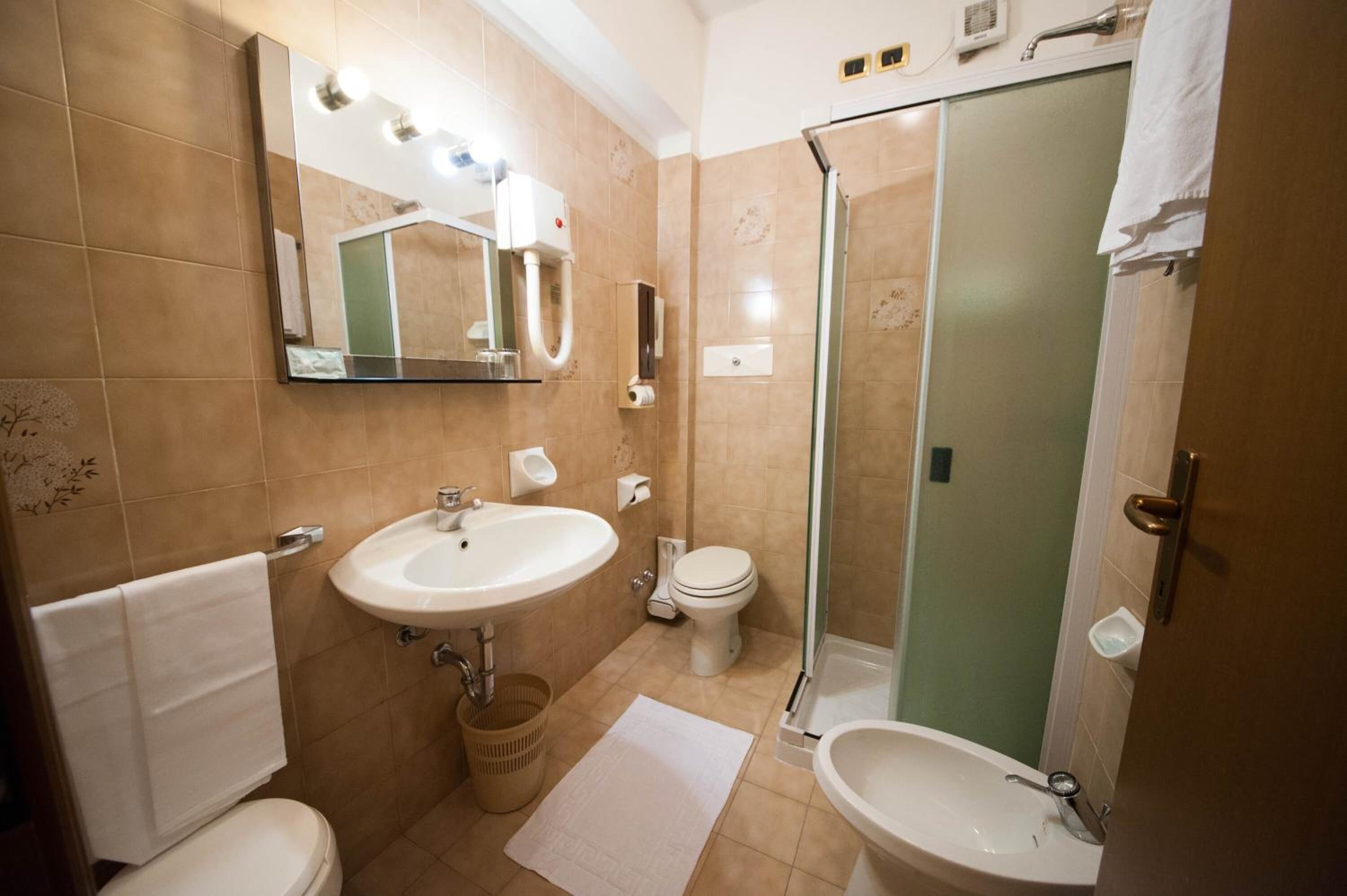 Une salle de bain avec un lavabo, des toilettes et une douche.