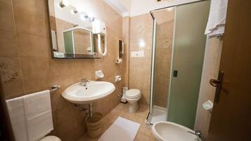 Une salle de bain avec un lavabo, des toilettes et une douche.
