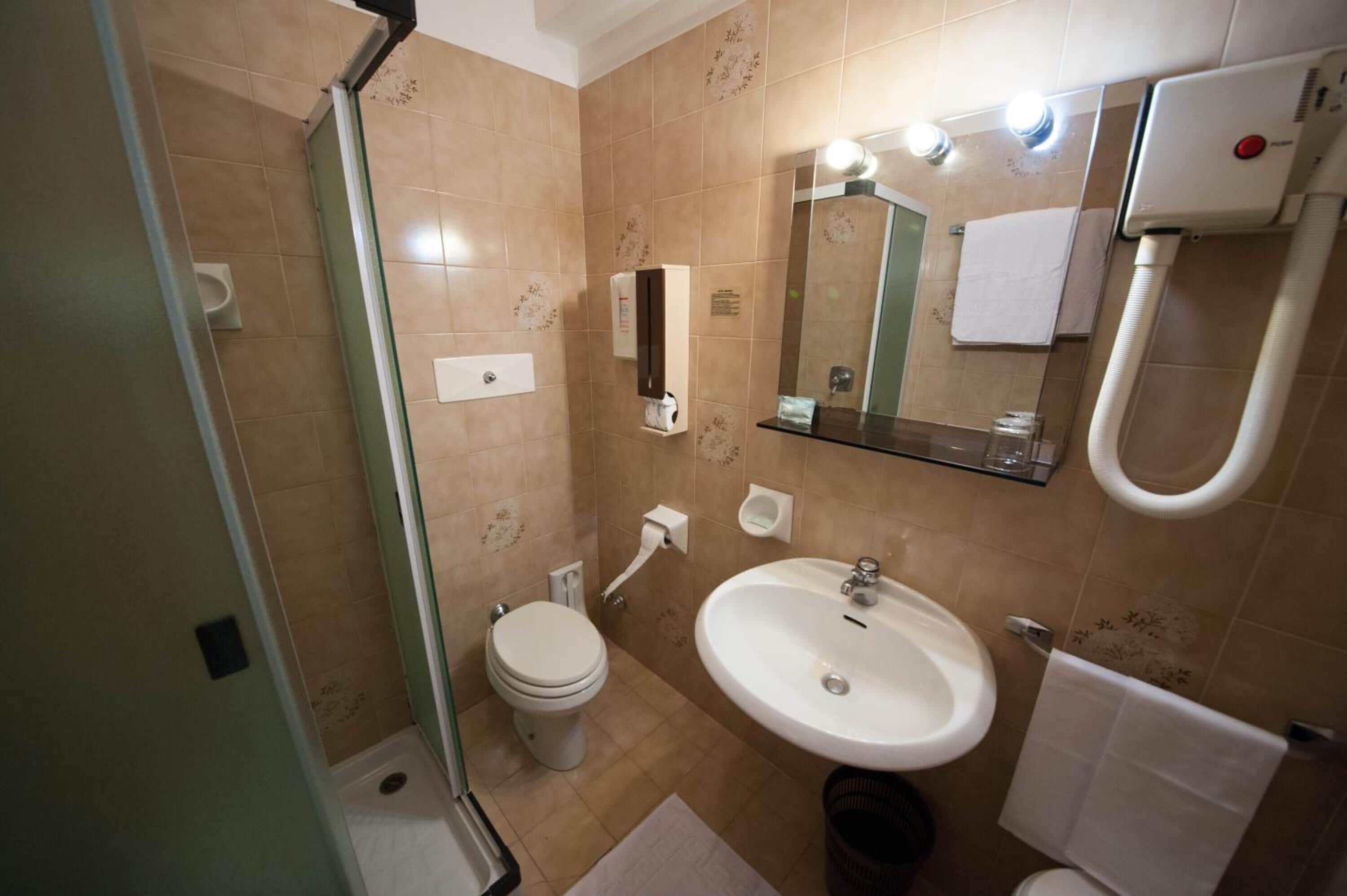 A bathroom with a toilet, sink, and shower.