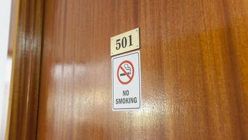 Una puerta de madera con un cartel que indica la habitación número 501 y un letrero de no fumar.