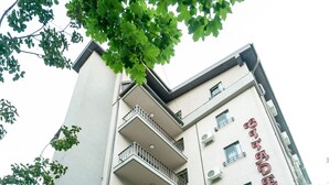 A multi-story hotel with balconies, potted plants, and a sign indicating it is a hotel. - Hotel Citadella Bucuresti (Bucharest)