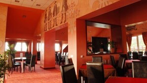 A hotel lobby with a red carpet, multiple dining tables, and chairs. - Pantex Hotel Brasov (Brasov)