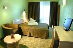 A hotel room with a bed, a desk, a chair, a small table, and a television. - Pantex Hotel Brasov (Brasov)