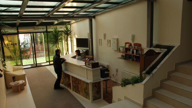 A reception area with a desk, a TV, and a staircase. - Pantex Hotel Brasov (Brasov)