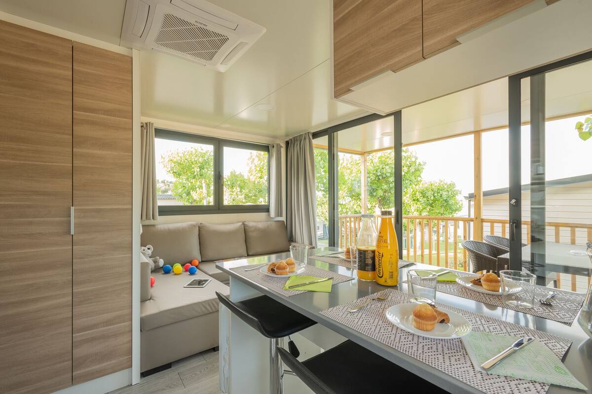 Uma cozinha moderna com área de refeições, grandes janelas e vista para o exterior.