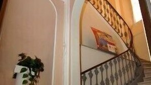 A staircase with a white railing and a potted plant on the left. - Albergo Alba (Turin)