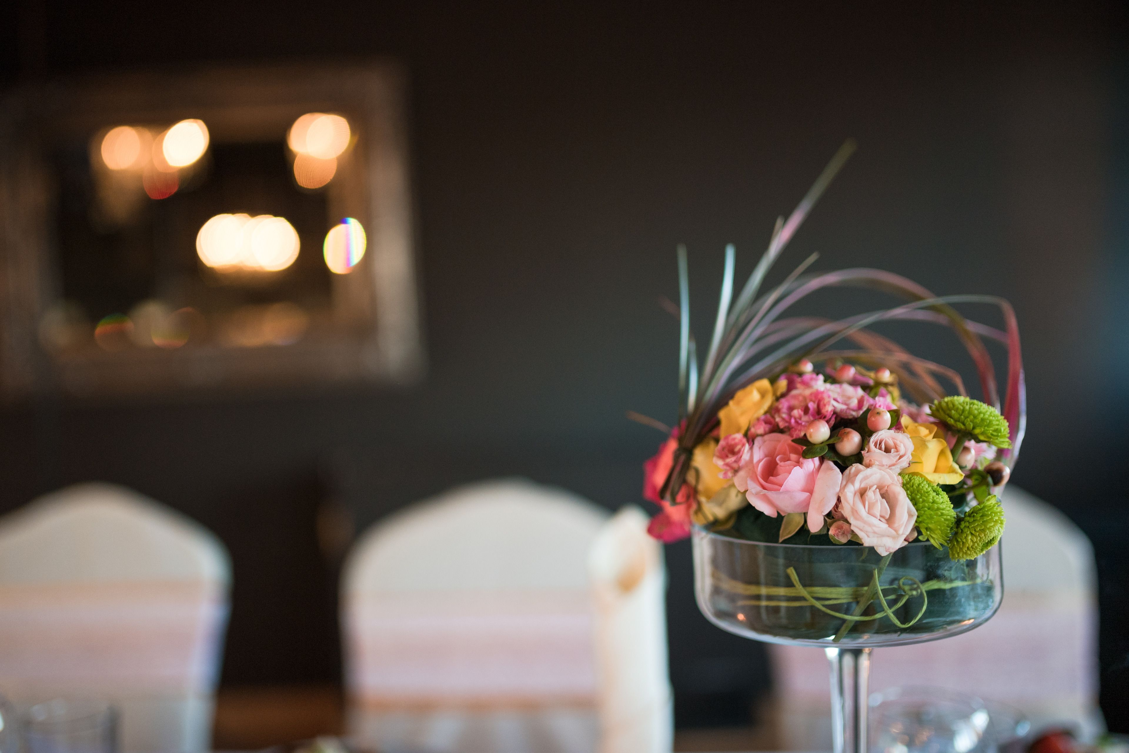 Une table sur laquelle se trouve un vase en verre transparent contenant un bouquet de fleurs.