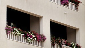 Un edificio con varios balcones decorados con macetas de flores.