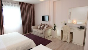 Una habitación de hotel con dos camas, un escritorio, una silla, un televisor y un espejo.