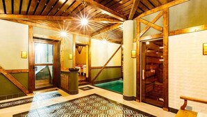 A hotel lobby with a pool, wooden beams, and a patterned floor. - Hotel Bankov (Kosice)