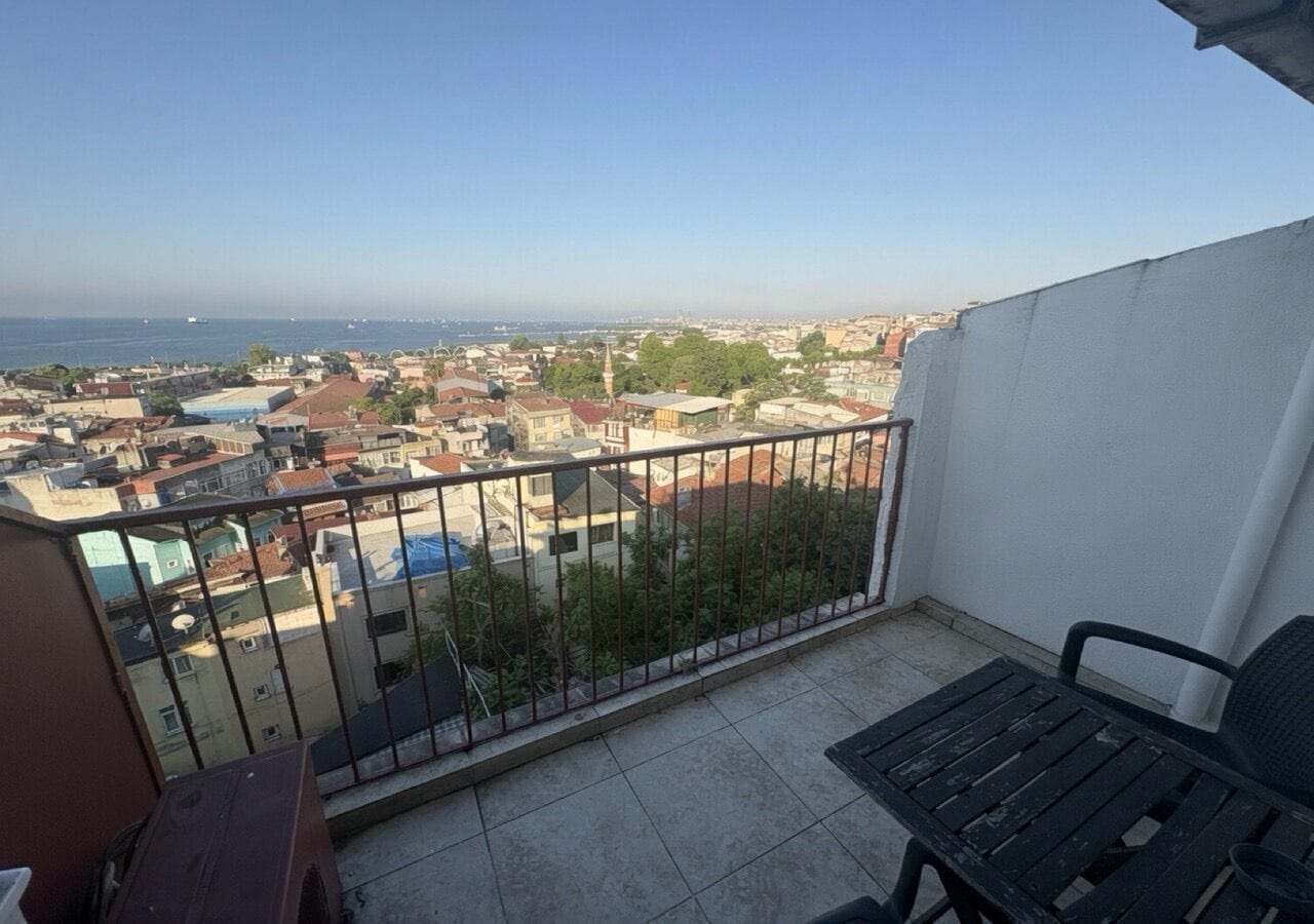 Un balcón con vista a un paisaje urbano y al mar.