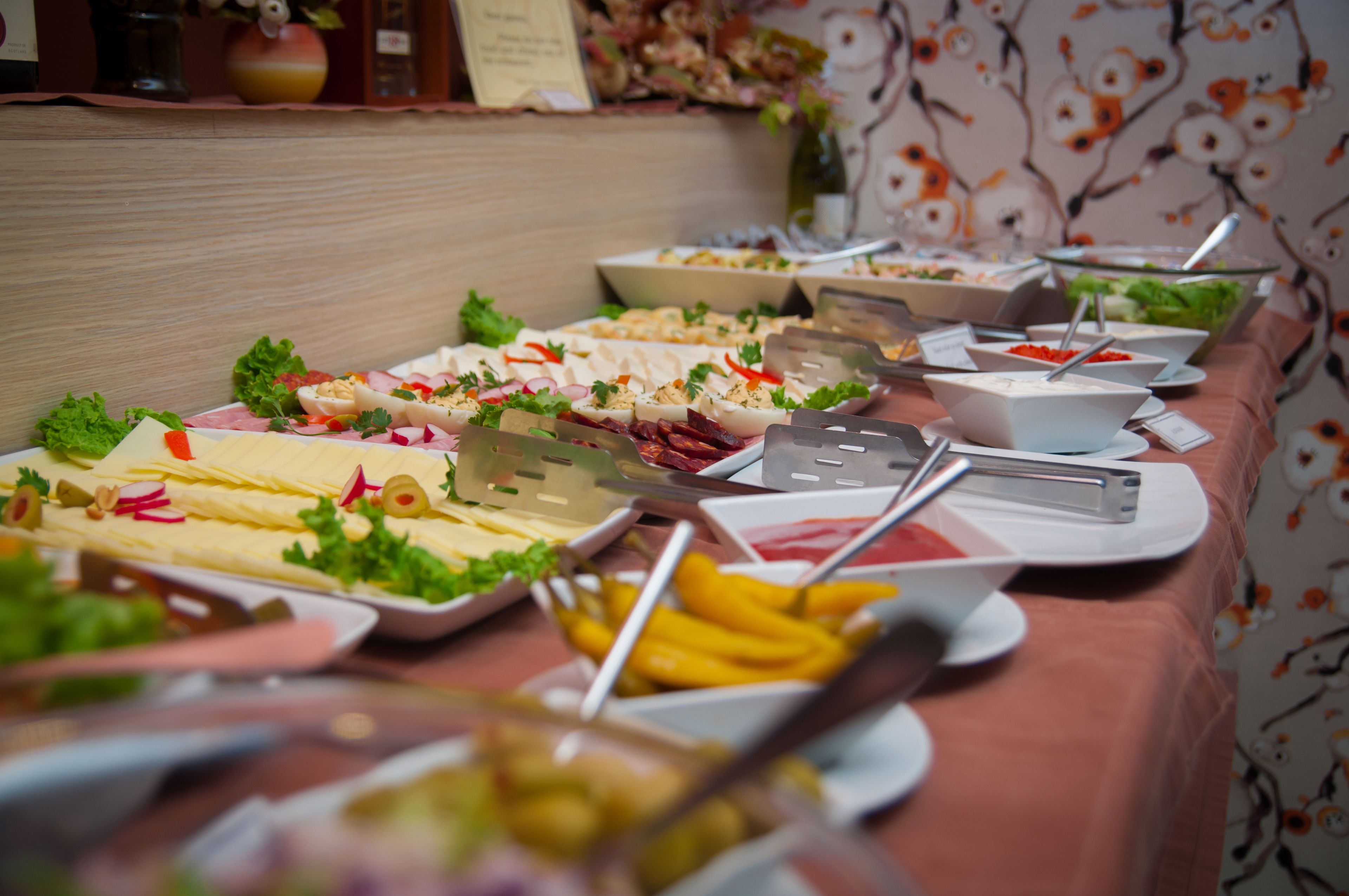A buffet table with various food items and serving utensils.