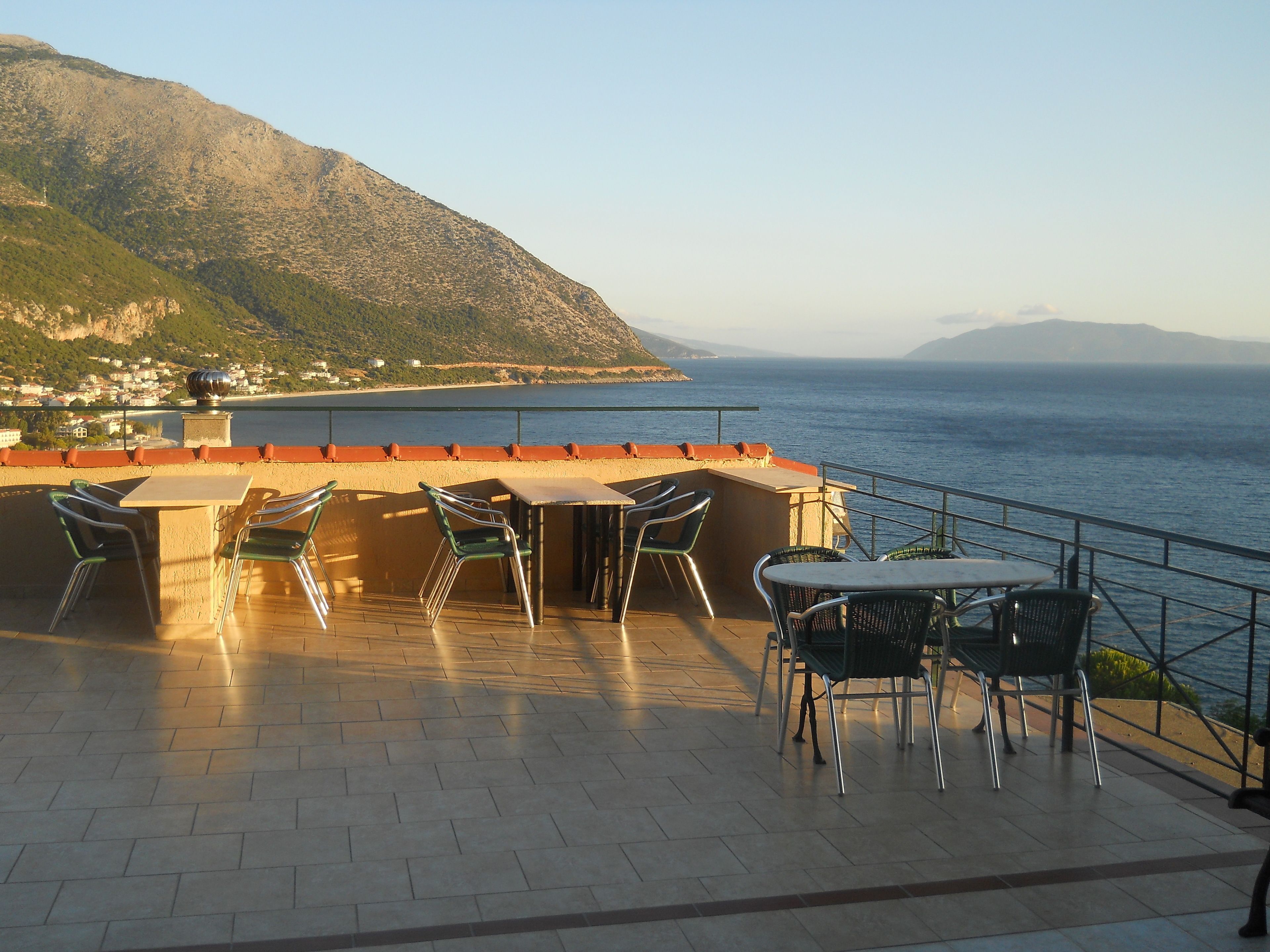 A terrace with outdoor seating overlooking a coastal view.
