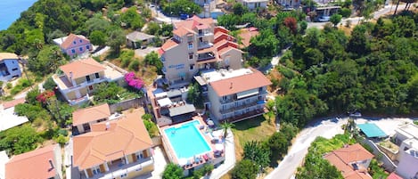 Zona residencial costera con varias casas de dos pisos, una piscina central y un hotel llamado Oceans Hotel.