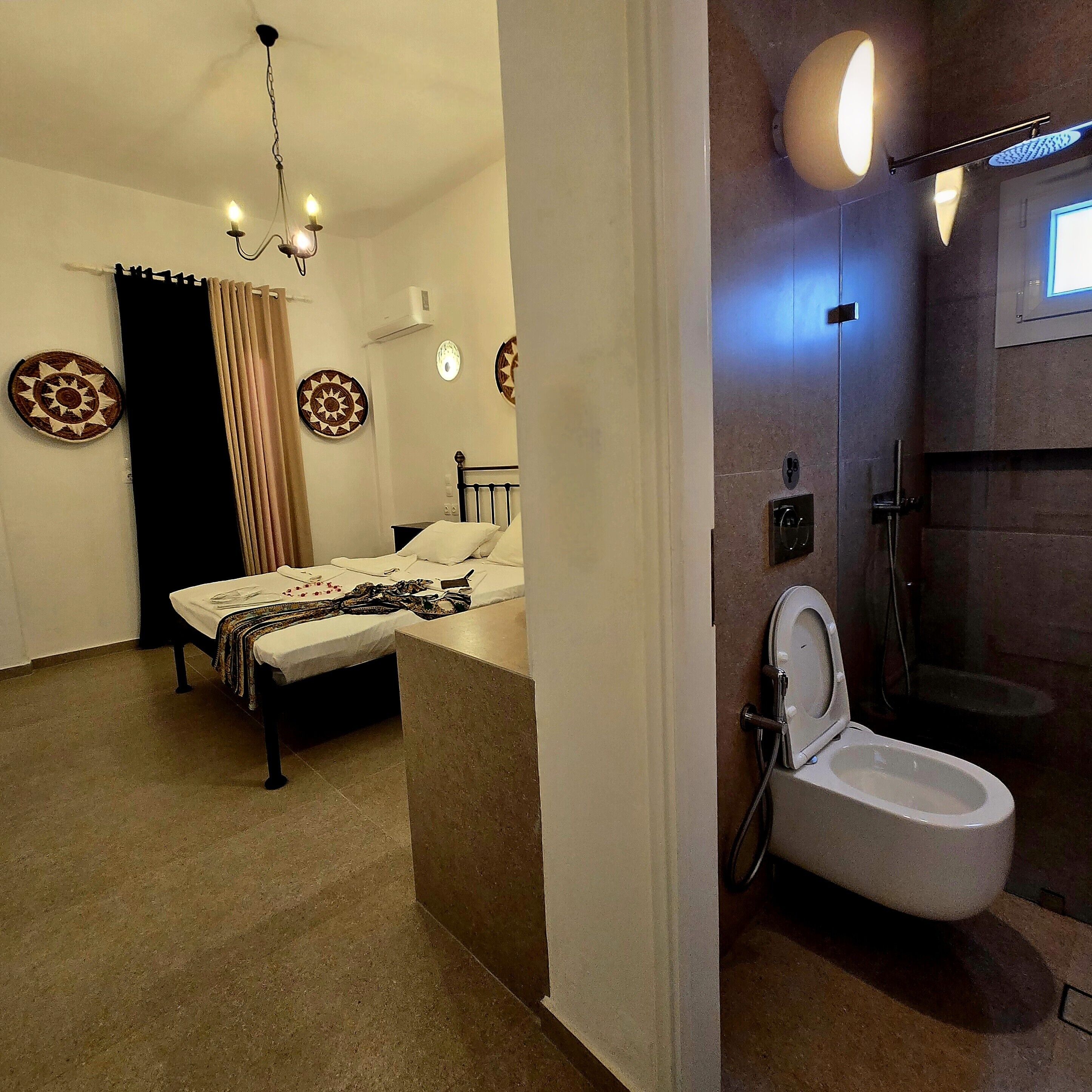 A bedroom with a bed, a bathroom with a toilet, and a shower.