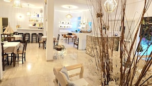 A spacious, well-lit interior with a dining area, kitchen, and seating space. - Afrodite Boutique Hotel (Paros)