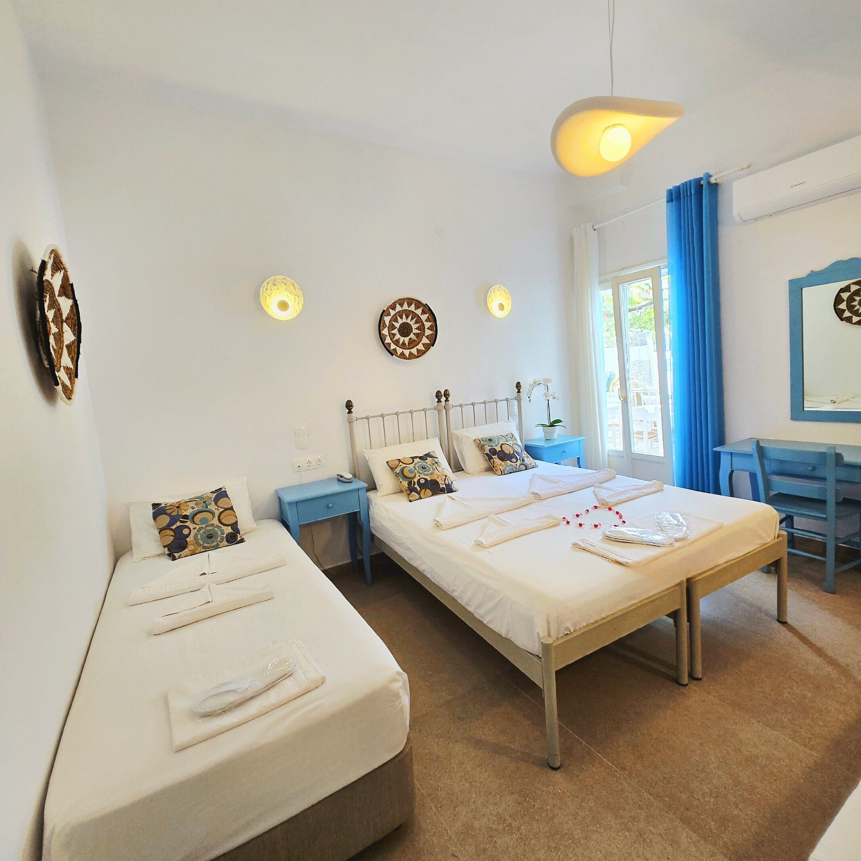 A hotel room with two beds, a desk, and a chair.