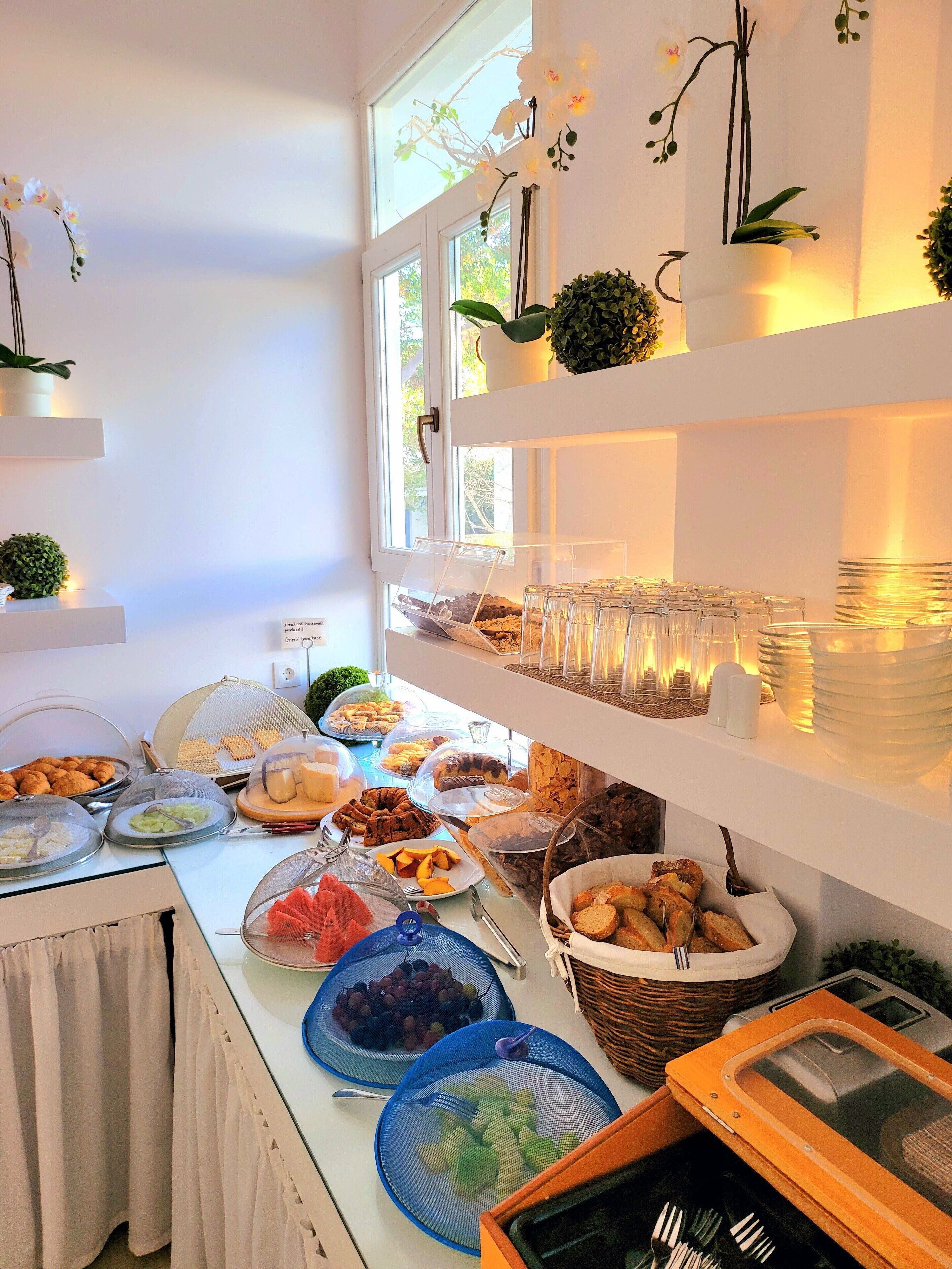 A buffet setup with various food items and glassware.