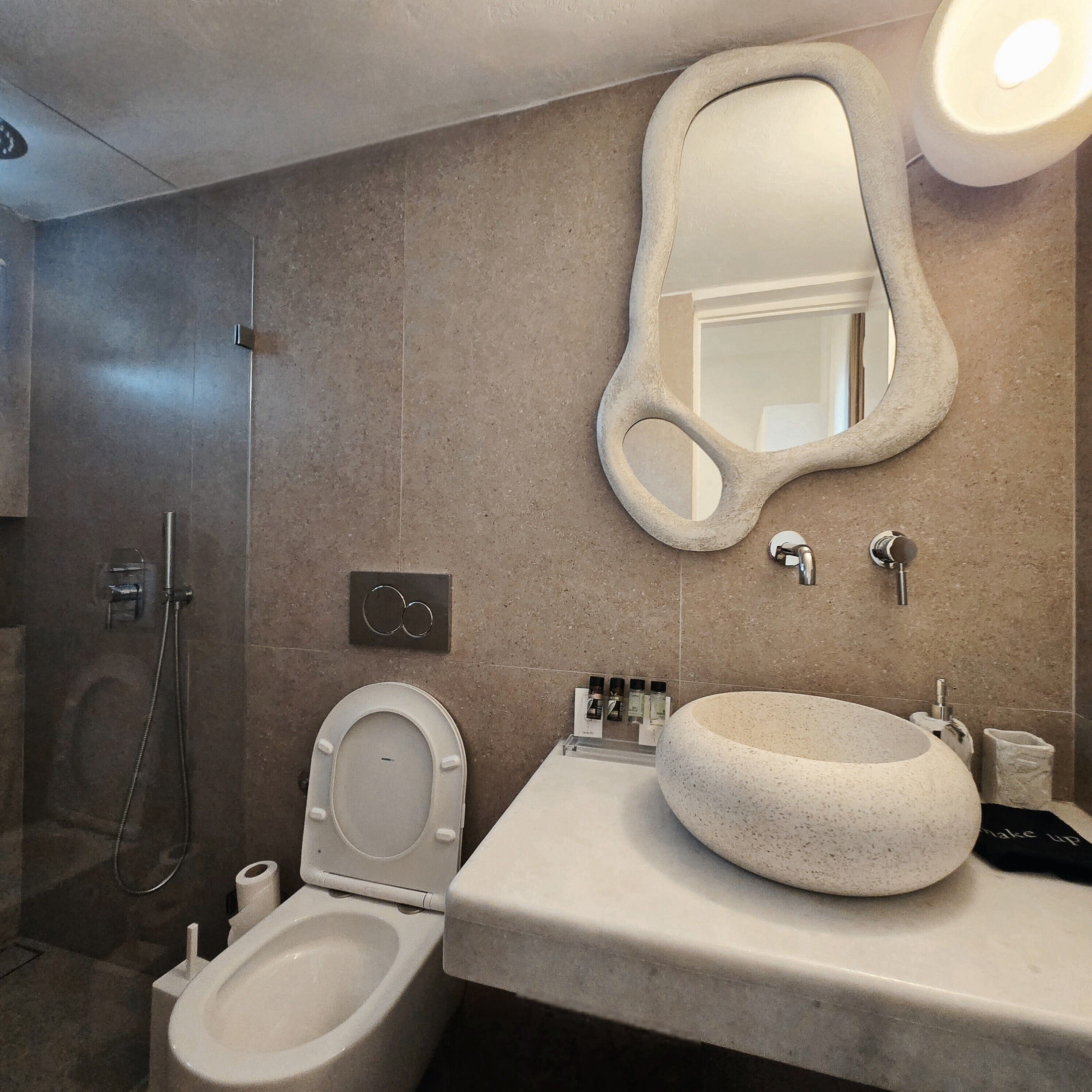 Een badkamer met toilet, bidet en een grote spiegel.