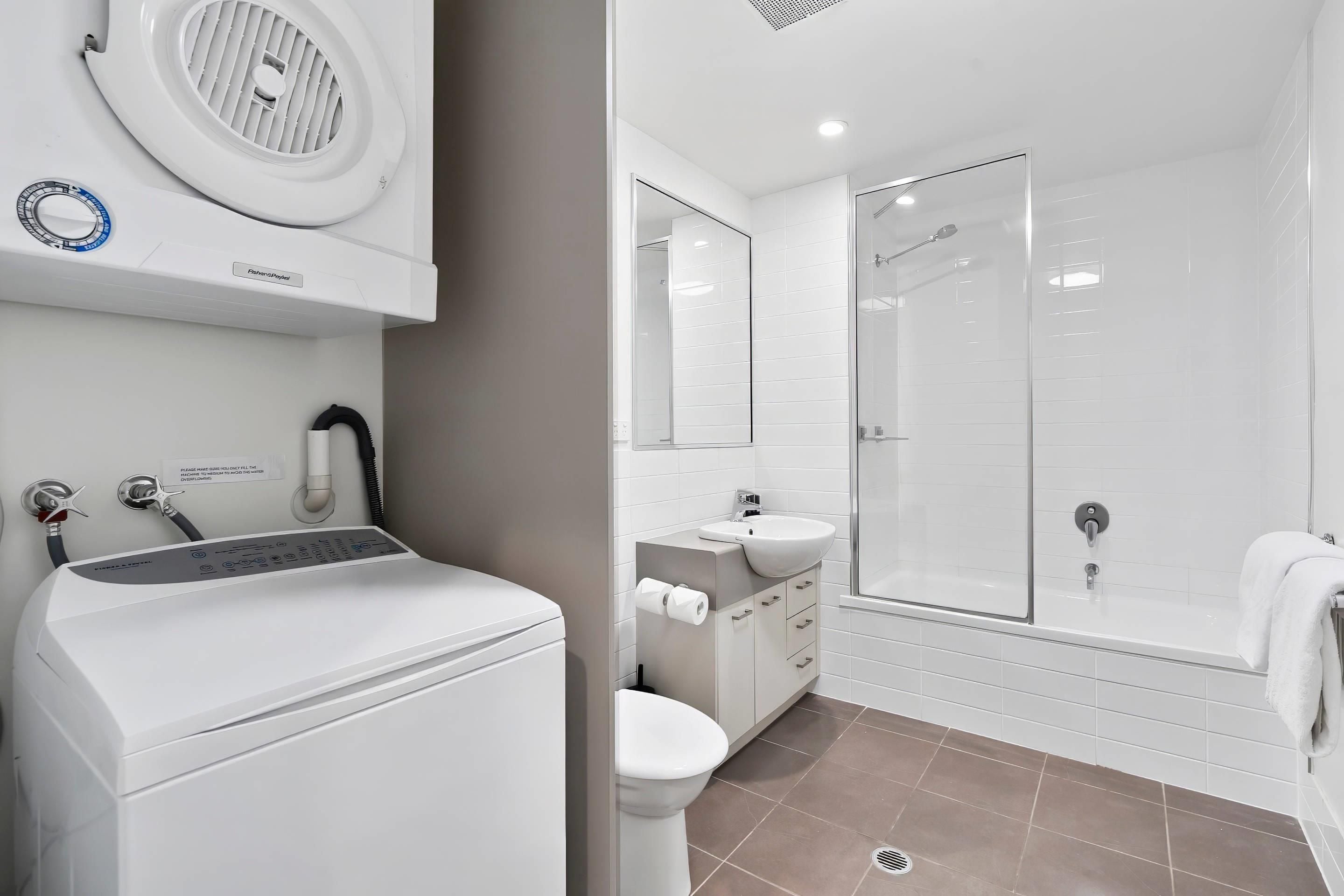 Un baño moderno con inodoro, lavamanos y zona de ducha.