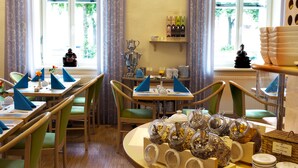 Un comedor con mesas dispuestas para el desayuno, que incluye alimentos para el desayuno y un bufé con diversas opciones.